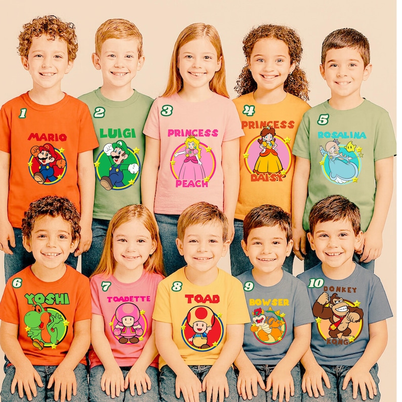 May include: A collection of ten short-sleeved t-shirts in various colors, each featuring a circular graphic of a Super Mario character. The shirts display the names Mario, Luigi, Princess Peach, Daisy, Rosalina, Yoshi, Toadette, Toad, Bowser, and Donkey Kong.