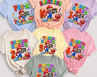 May include: A collection of seven short-sleeved t-shirts in various pastel colors, each featuring a graphic of Mario holding a chalkboard with grade levels from Pre-K to Fifth Grade, along with the text Let's Go 2026 and school supplies.