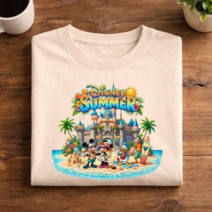 May include: A beige crew neck t-shirt featuring a colorful graphic of Disney characters including Mickey, Minnie, Donald, and Goofy on a beach in front of a castle. The text Disney SUMMER is printed in blue and orange above the characters.