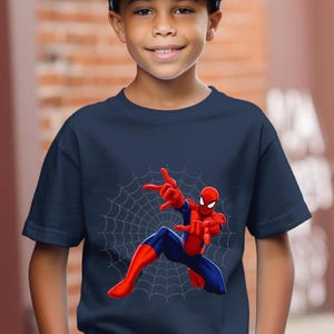 Puede incluir: Camiseta azul marino con un dise&ntilde;o de Spider-Man en una pose din&aacute;mica sobre una telara&ntilde;a blanca. El superh&eacute;roe lleva su traje cl&aacute;sico rojo y azul, con las manos extendidas. La camiseta es de cuello redondo y manga corta.