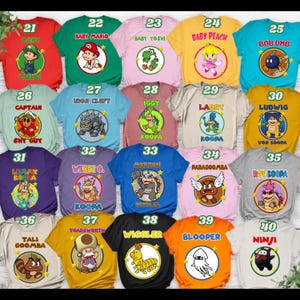 May include: A collection of twenty t-shirts in various colors, each featuring a circular graphic of a Nintendo character with their name printed above or below. The shirts are numbered 21 through 40, displaying characters like Baby Mario, Yoshi, Peach, and various Koopalings.
