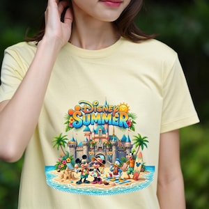 May include: A pale yellow t-shirt featuring a colorful graphic print of Disney characters including Mickey Mouse, Minnie Mouse, Donald Duck, and Goofy on a beach in front of a castle. The text Disney SUMMER is printed in blue and orange above the scene.