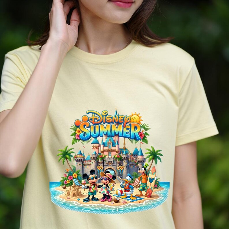 May include: A pale yellow t-shirt featuring a colorful graphic print of Disney characters including Mickey Mouse, Minnie Mouse, Donald Duck, and Goofy on a beach in front of a castle. The text Disney SUMMER is printed in blue and orange above the scene.