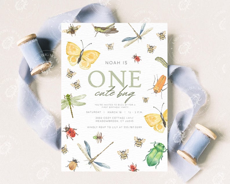Pode incluir: Um cart&atilde;o de convite branco com ilustra&ccedil;&otilde;es em aquarela de insetos, incluindo borboletas, abelhas e lib&eacute;lulas. O texto diz "NOAH IS ONE cute bug" com detalhes da festa. Fita azul clara e uma bobina de madeira no fundo.