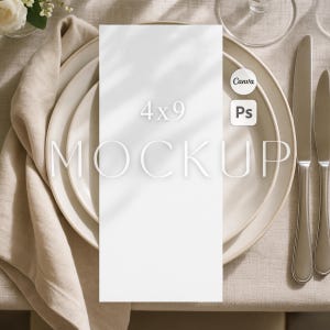 Może przedstawiać: Biała karta makiety 4x9 cali (około 10x23 cm) ze słowem "MOCKUP" w minimalistycznej czcionce, umieszczona na ustawieniu stołu. Ustawienie obejmuje talerze, sztućce i lnianą serwetkę. Obraz zawiera również tekst "Canva" i "Ps".