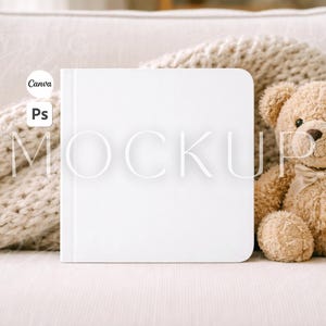 May include: A white square book mockup with rounded corners, placed next to a beige teddy bear with a ribbon bow. The book is on a light-colored surface, with a knitted blanket in the background. The word "MOCKUP" is overlaid on the book.