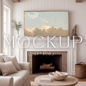 Op de afbeelding: Woonkamer mockup met een ingelijst landschapsschilderij boven een witte open haard. De kamer bevat een beige bank, een ronde houten salontafel en een rieten mand. De tekst "MOCKUP" en "PSD + PNG" zijn zichtbaar.