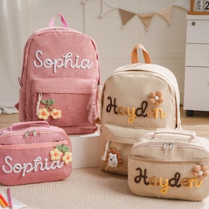 Peut inclure: Deux sacs à dos en velours côtelé et deux sacs à déjeuner assortis en rose et beige. Les articles roses sont brodés du nom Sophia et présentent des motifs de cerises. Les articles beiges sont brodés du nom Hayden et présentent des motifs de fleurs.