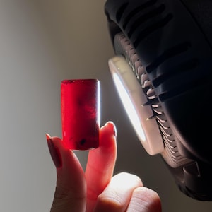 El fuego interior: cilindro de ámbar marrón miel oscuro con transparencia rojo fuego. Pieza de exhibición de gemas.
