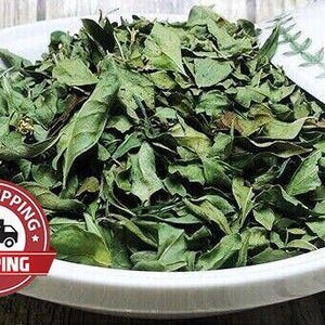 May include: A white bowl filled with dried green leaves. The leaves are the primary focus, with a variety of shapes and textures. The bowl has a decorative edge. A red and white "Free Shipping" sticker is in the lower left corner.