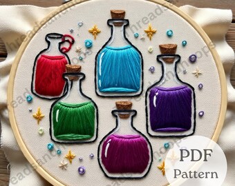 Peut inclure: Broderie sur tambour représentant cinq fioles de potion colorées avec des bouchons en liège. Les fioles sont remplies de fil rouge, bleu, vert, violet et magenta. Le motif comprend des étoiles dorées et de petites perles. Le texte "PDF Pattern" est visible.