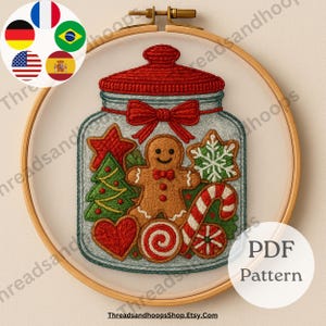 May include: An embroidery hoop features a festive design of a jar filled with Christmas cookies. The jar has a red lid and bow, with a gingerbread man, candy cane, and other holiday shapes. The text "PDF Pattern" is visible.