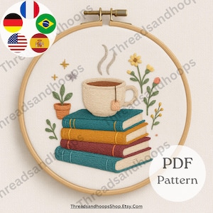 May include: Embroidered hoop art featuring a stack of books, a teacup with steam, and floral accents. The design includes a small potted plant and the text "PDF Pattern". The color palette includes teal, gold, red, and cream.