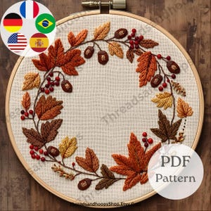 Puede incluir: Un bastidor de bordado con un diseño de temática otoñal. El diseño incluye hojas bordadas en tonos marrones, naranjas y amarillos, junto con bayas rojas y bellotas. El texto "PDF Pattern" es visible en la parte inferior derecha.