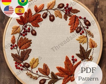 Puede incluir: Un bastidor de bordado con un diseño de temática otoñal. El diseño incluye hojas bordadas en tonos marrones, naranjas y amarillos, junto con bayas rojas y bellotas. El texto "PDF Pattern" es visible en la parte inferior derecha.