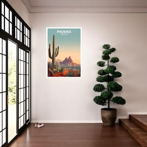 May include: A framed art print featuring a desert landscape with a large cactus, mountains, and the text "PHOENIX ARIZONA" in white. The artwork has a color palette of orange, green, and blue.