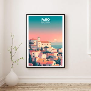May include: A framed art print featuring a stylized illustration of Faro, Portugal. The artwork depicts white buildings with orange rooftops, green trees, and a teal and pink sky. The word "FARO" and "PORTUGAL" are printed at the top.