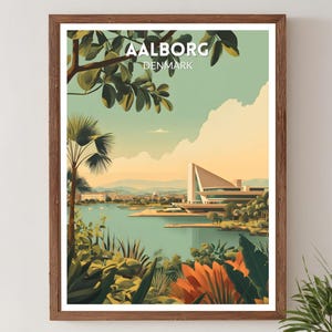 May include: A framed art print featuring a scenic view of Aalborg, Denmark. The artwork showcases a modern building by a lake, with lush greenery and the text "AALBORG DENMARK" at the top. The color palette includes greens, blues, and oranges.