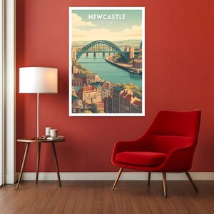 May include: A framed art print featuring a stylized illustration of Newcastle, England. The artwork depicts a green arched bridge over a river, with buildings and a blue sky. The text "NEWCASTLE ENGLAND" is at the top.