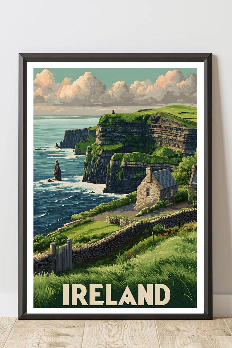 K&ouml;nnte beinhalten: Gerahmter Druck der irischen K&uuml;ste mit den Cliffs of Moher. Das Kunstwerk zeigt ein Steinh&auml;uschen, gr&uuml;ne Klippen und das Meer unter einem bew&ouml;lkten Himmel. Das Wort "IRELAND" ist unten aufgedruckt.