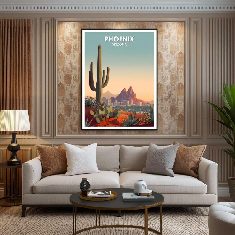 May include: A framed art print featuring a stylized desert landscape with a large saguaro cactus, mountains, and the city skyline of Phoenix, Arizona. The print has a blue and orange color palette with the text "PHOENIX ARIZONA" at the top.