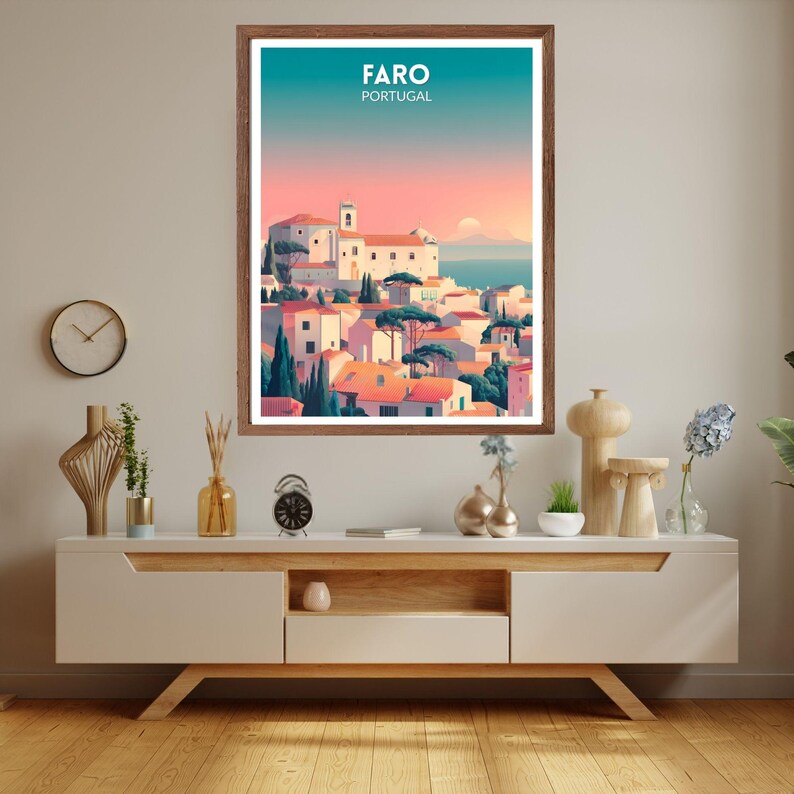 May include: A framed art print featuring a colorful illustration of Faro, Portugal. The artwork depicts a coastal town with white buildings, orange rooftops, and green trees under a gradient sky. The text "FARO PORTUGAL" is at the top.
