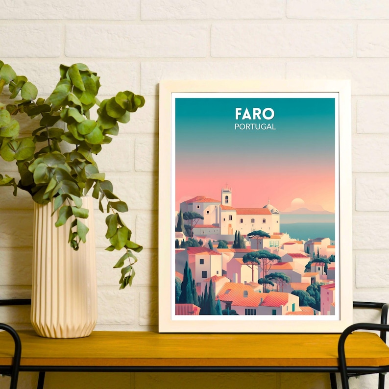 May include: Framed art print featuring a stylized illustration of Faro, Portugal. The artwork depicts white buildings with red tile roofs, set against a gradient sky of teal, pink, and orange. The text "FARO PORTUGAL" is displayed at the top.
