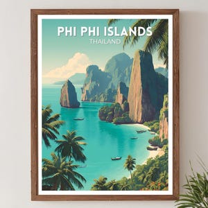 May include: A framed art print of Phi Phi Islands, Thailand. The artwork shows a tropical scene with turquoise water, large rock formations, and palm trees. The words "PHI PHI ISLANDS" and "THAILAND" are printed at the top.