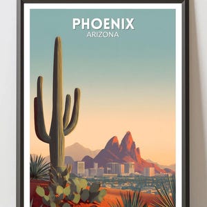 May include: Framed art print featuring a desert landscape with a large saguaro cactus in the foreground. The image includes the text "PHOENIX ARIZONA" at the top, with a city skyline and mountains in the background. The color palette includes shades of green, orange, and blue.
