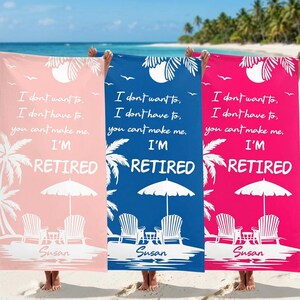 May include: Three beach towels in pink, blue, and fuchsia, each with the text "I'M RETIRED" and a beach scene. The towels feature a palm tree, beach chairs, and an umbrella design. Each towel has the name "Susan" printed on it.