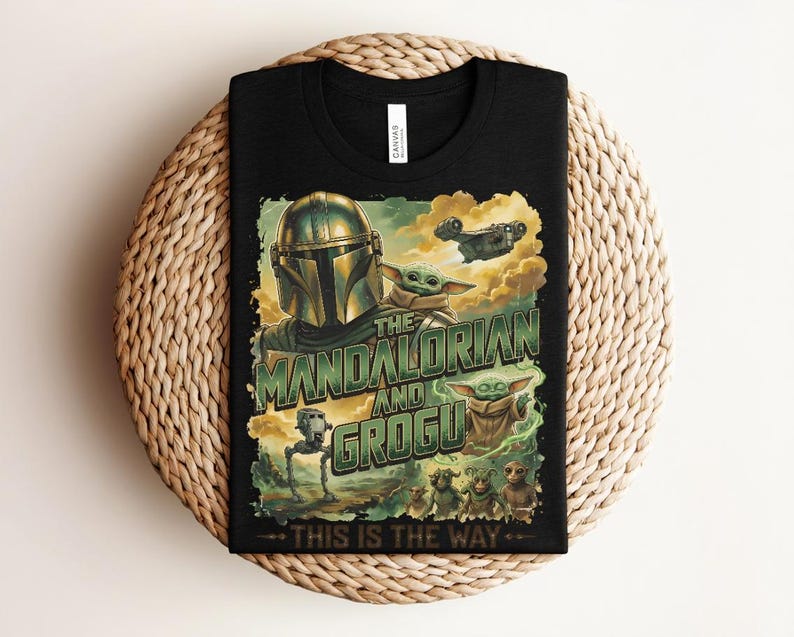 Puede incluir: Una camiseta negra con un estampado gr&aacute;fico de The Mandalorian y Grogu. El dise&ntilde;o incluye el texto "THE MANDALORIAN AND GROGU" y "THIS IS THE WAY" en letras verdes, junto con ilustraciones de una nave espacial, un AT-ST y varias criaturas.