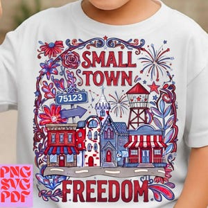 Könnte beinhalten: Weißes T-Shirt mit einem farbenfrohen Grafikdesign einer Kleinstadt mit den Worten "SMALL TOWN FREEDOM". Das Design umfasst Gebäude, Feuerwerk und florale Elemente in Rot, Weiß und Blau.
