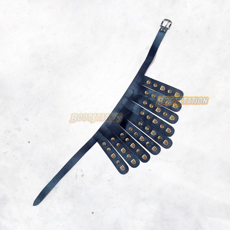 May include: A dark blue leather gorget with brass-colored rivets and decorative accents. The gorget has a buckle closure and multiple straps. The product is designed to be worn around the neck and shoulders.