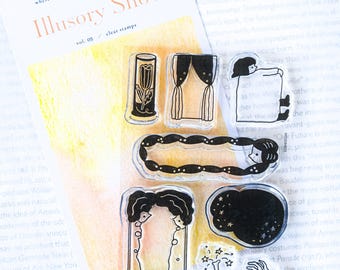 Puede incluir: Sellos transparentes con ilustraciones caprichosas, incluyendo un tulipán, cortinas y figuras. El conjunto también presenta una noche estrellada, un marco y el texto "Illusory Show vol. 05 clear stamps".