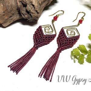 May include: Burgundy red macrame earrings with gold wire accents and red beads. The earrings have a tassel design and are approximately 3 inches long.
