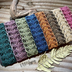 May include: A collection of eight rectangular fabric pouches featuring a decorative macrame overlay in various colors including teal, mauve, sage green, blue, orange, brown, beige, and pink, with the text VW Gypsy printed on the surface.