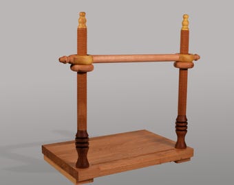 May include: A wooden book press with a rectangular base and two threaded vertical supports. A horizontal bar connects the supports. The press features a natural wood finish with darker accents and a screw mechanism for adjustment.