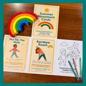 Op de afbeelding: Een houten regenboog ligt op een set kleurrijke activiteitkaarten voor kinderen. De kaarten bevatten illustraties en instructies voor bewegingsactiviteiten voor peuters, waaronder "Sky Tip-Toe Walk" en "Rainbow Reach". De kaarten heten "Summer Movement Cards".