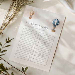 May include: A printable baby shower game titled "Would He Rather?" features a soft watercolor design with hot air balloons. The game includes fill-in-the-blank questions about baby care, perfect for a fun and interactive baby shower activity.