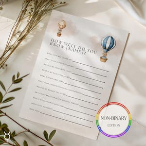 May include: A printed game sheet with the text "How Well Do You Know [Name]?" and hot air balloon illustrations. Includes fill-in-the-blank questions and a "Non-Binary Edition" rainbow circle.