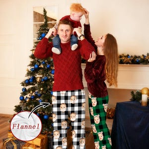Op de afbeelding: Familie in bijpassende flanellen pyjama's. De pyjama's hebben een aangepaste gezichtsprint op een zwart-wit geruit patroon en een groen-zwart geruit patroon. Ze staan voor een kerstboom.