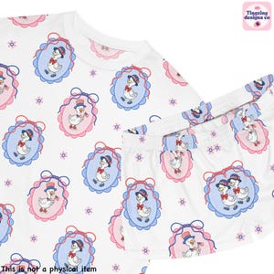 Pu&ograve; includere: Pigiama bianco con un motivo ripetuto di oche dei cartoni animati con cappelli patriottici all'interno di cornici ovali blu e rosa. Il set include una maglietta a maniche corte e pantaloncini abbinati, con piccoli accenti floreali.