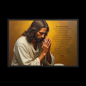 May include: Framed artwork featuring a depiction of Jesus in prayer, with hands clasped and eyes closed. The artwork includes the text of The Lord's Prayer in a vertical column on the right side, set against a warm, golden background.