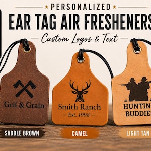 May include: Three personalized ear tag air fresheners in saddle brown, camel, and light tan leather-like material. Each tag features a black elastic cord, a metal grommet, and custom black laser-engraved designs including axes, a deer, and hunters.