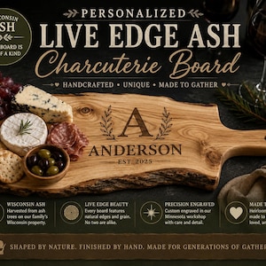 May include: A personalized live edge ash charcuterie board featuring a natural wood grain and bark edge. The board is engraved with the letter A, the name ANDERSON, and the text EST. 2025. It is displayed with grapes, cheese, crackers, and olives.