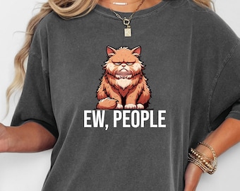 May include: Dark gray t-shirt featuring a grumpy cartoon cat with orange and brown fur. The cat is sitting with a displeased expression. The text "EW, PEOPLE" is printed in white below the cat.