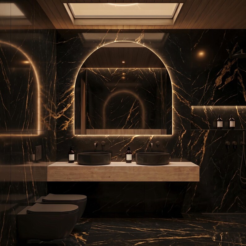 May include: A modern bathroom with black marble walls and flooring, featuring a large arched mirror with a warm light. Two black vessel sinks sit on a light-colored countertop. The room includes two black toilets and a wooden ceiling.