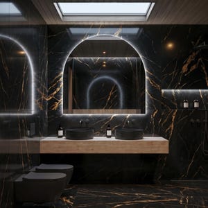 May include: A modern bathroom with black marble walls and flooring, accented with gold veining. Features include a large arched mirror with integrated lighting, two black vessel sinks, and a wooden countertop. The room is illuminated by a skylight.