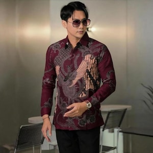 Op de afbeelding: Bordeauxkleurig shirt met lange mouwen en een gedetailleerd feniksontwerp in grijs en beige. Het shirt heeft een button-down kraag en een patroonprint. Een stijlvolle toevoeging aan elke garderobe.