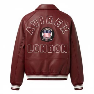 May include: A burgundy leather varsity jacket featuring a white collar and striped ribbed cuffs and hem. The back displays the text AVIREX in an arc, the word LONDON below, and a circular patch with an American flag and the text ALL AMERICANS ESTABLISHED 1975.